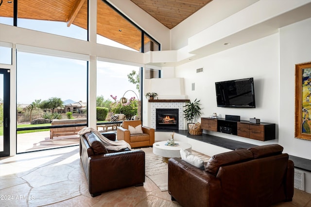 living room featuring beam ceiling, high vaulted ceiling, wooden ceiling, and a fireplace