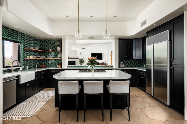 kitchen with a kitchen island, stainless steel appliances, tasteful backsplash, and a breakfast bar area