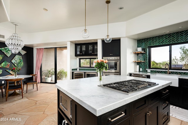 kitchen with a kitchen island, stainless steel appliances, an inviting chandelier, and a healthy amount of sunlight