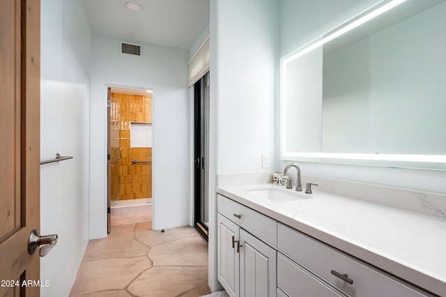 bathroom featuring a shower with shower door and vanity