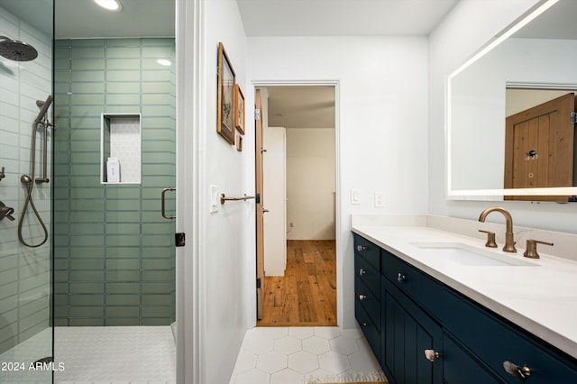 bathroom featuring a shower with shower door, hardwood / wood-style floors, and vanity