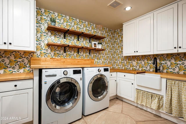 laundry room with cabinets, washer and clothes dryer, and sink