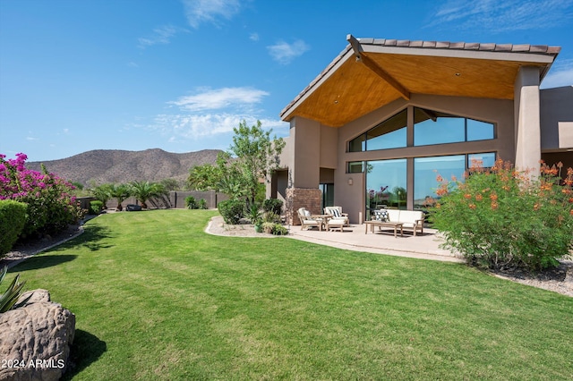 view of yard with an outdoor living space, a mountain view, and a patio