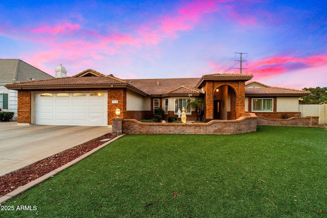 view of front of home with a tile roof, stucco siding, concrete driveway, a front yard, and a garage