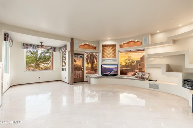 unfurnished living room with visible vents, baseboards, and ceiling fan