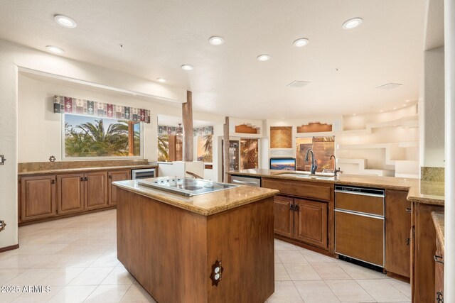 kitchen with electric stovetop, brown cabinets, a kitchen island, and a sink