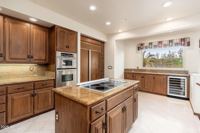 kitchen featuring wine cooler, electric cooktop, double oven, tasteful backsplash, and a center island