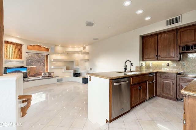 kitchen featuring visible vents, open floor plan, dishwasher, decorative backsplash, and a sink