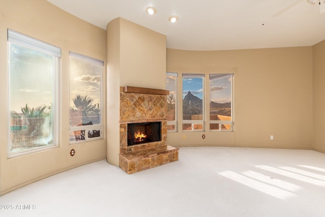 carpeted living area with a tiled fireplace