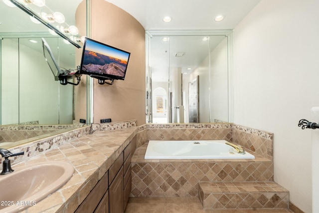 bathroom with vanity, a garden tub, and recessed lighting