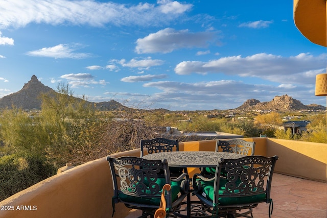 balcony featuring a mountain view and outdoor dining area