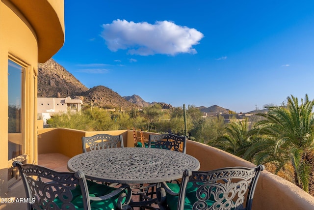 view of patio featuring a balcony, outdoor dining area, and a mountain view