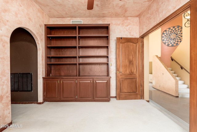 interior space with light carpet, visible vents, and a ceiling fan