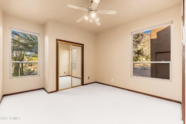 unfurnished bedroom featuring a closet, baseboards, ceiling fan, and carpet flooring