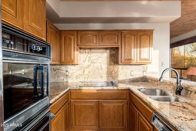 kitchen featuring a sink, decorative backsplash, brown cabinets, and black appliances