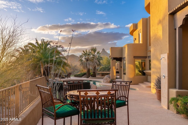 patio terrace at dusk featuring an outdoor pool