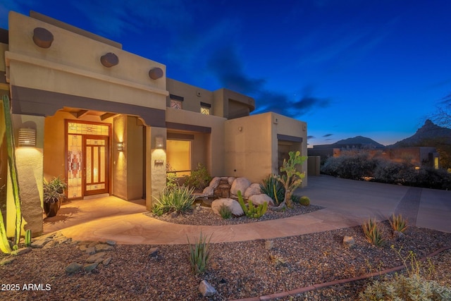 view of front of home featuring a mountain view, driveway, and stucco siding