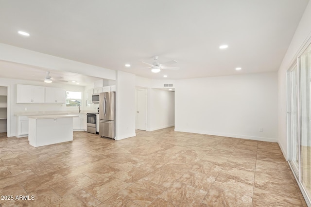 unfurnished living room with ceiling fan