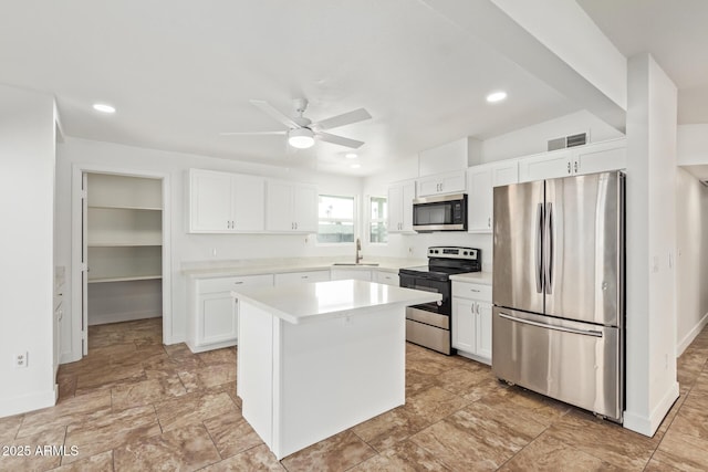 kitchen featuring white cabinetry, sink, a kitchen island, and appliances with stainless steel finishes