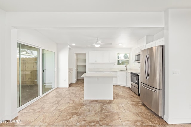 kitchen featuring white cabinetry, sink, a center island, ceiling fan, and stainless steel appliances