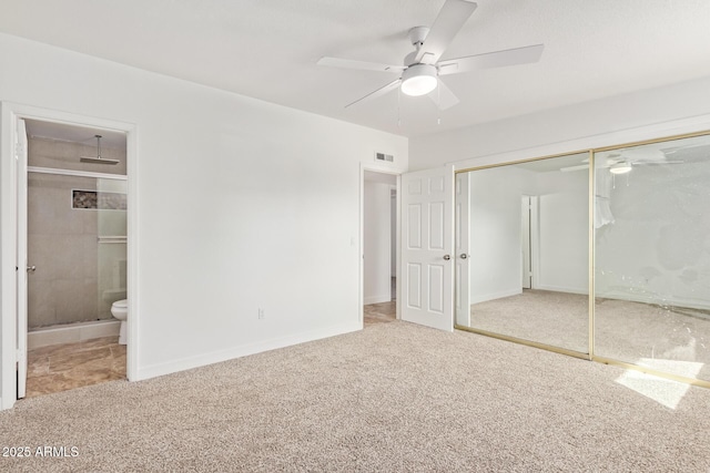 unfurnished bedroom with connected bathroom, light colored carpet, ceiling fan, and a closet