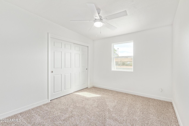 unfurnished bedroom featuring carpet floors, a closet, and ceiling fan