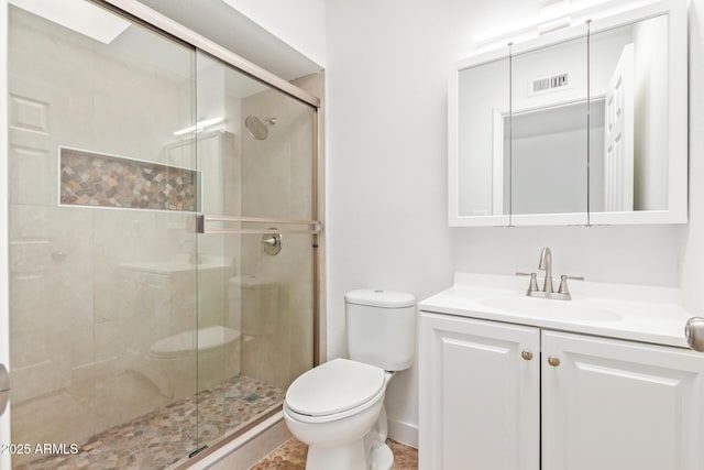 bathroom with vanity, toilet, and a shower with shower door