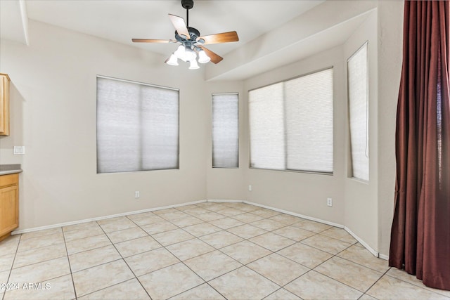 tiled spare room with ceiling fan