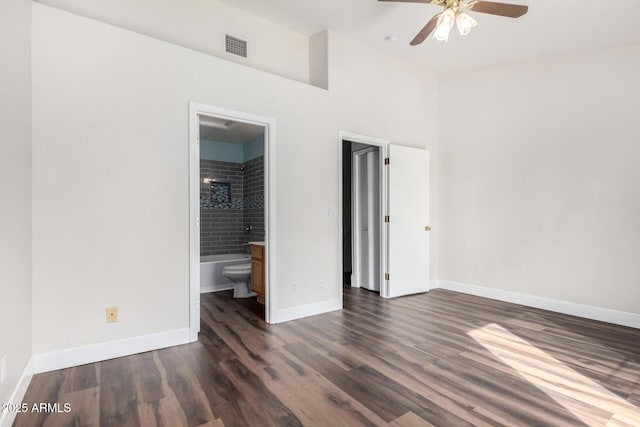 unfurnished bedroom featuring dark wood finished floors, a ceiling fan, baseboards, and ensuite bathroom