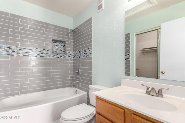 bathroom with visible vents, toilet, tub / shower combination, vanity, and a textured wall