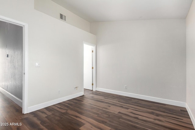 unfurnished room with dark wood finished floors, baseboards, and visible vents