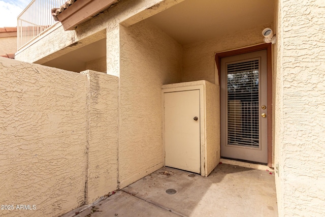 entrance to property featuring stucco siding