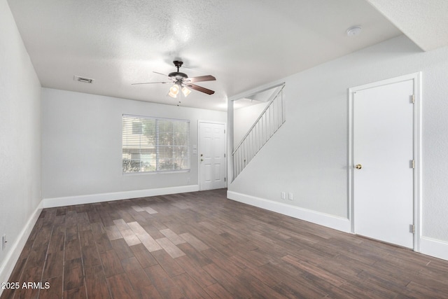 spare room with visible vents, baseboards, stairway, wood finished floors, and a ceiling fan