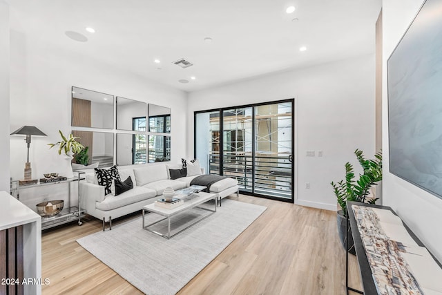 living room featuring recessed lighting, baseboards, visible vents, and light wood-type flooring