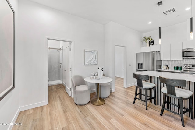 dining area with visible vents, recessed lighting, light wood finished floors, and baseboards