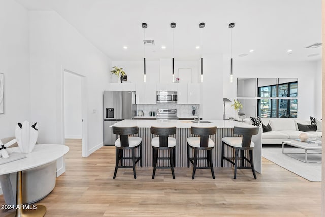 kitchen with visible vents, decorative backsplash, appliances with stainless steel finishes, and a kitchen breakfast bar