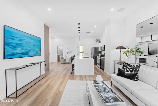 living area featuring recessed lighting, baseboards, and light wood finished floors