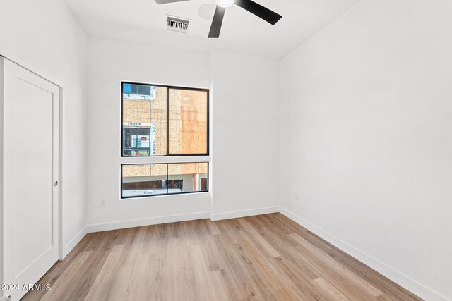 spare room featuring a ceiling fan, baseboards, visible vents, and light wood-style floors