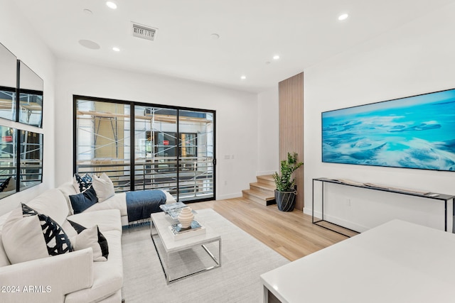 living area featuring visible vents, baseboards, stairway, recessed lighting, and light wood finished floors