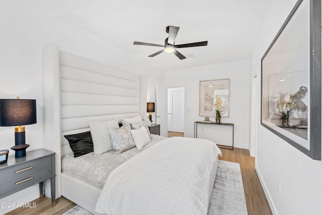 bedroom with baseboards, ceiling fan, and wood finished floors