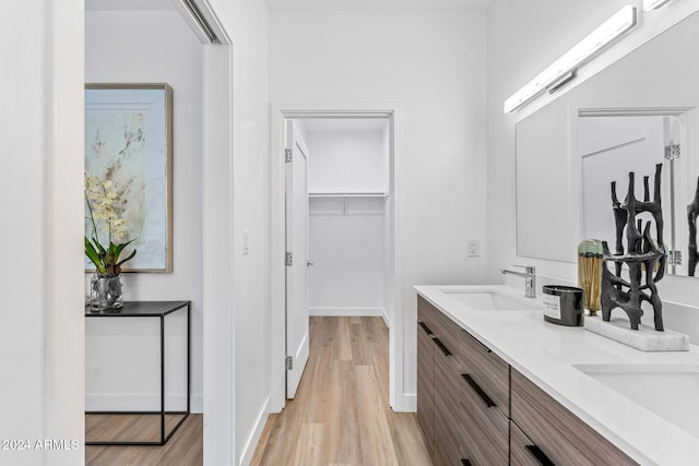 bathroom featuring double vanity, a sink, and wood finished floors