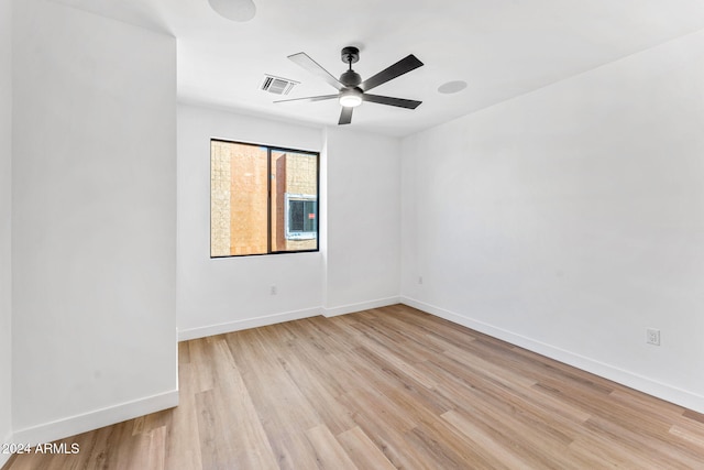spare room featuring baseboards, ceiling fan, visible vents, and light wood-style flooring
