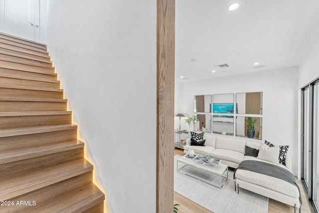 staircase with recessed lighting, visible vents, and wood finished floors