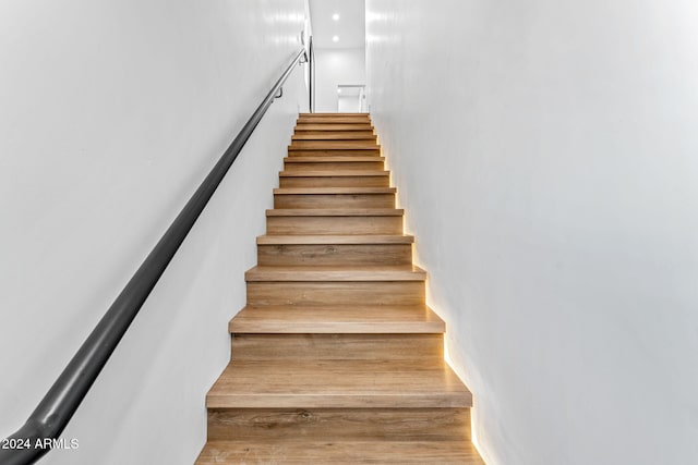 stairs featuring recessed lighting and wood finished floors