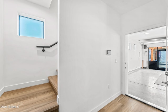 interior space featuring baseboards, light wood-style flooring, and stairway