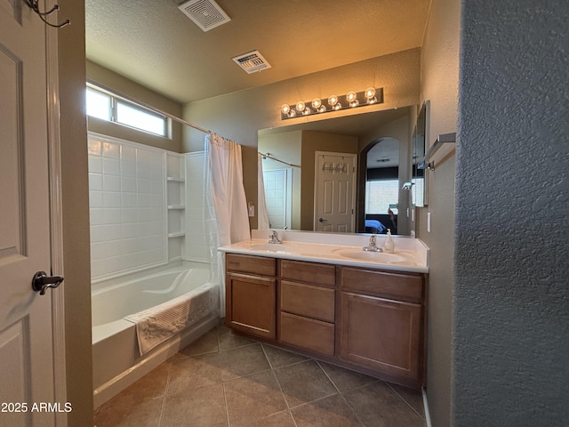 bathroom with vanity, tile patterned flooring, shower / bath combination with curtain, and a textured ceiling