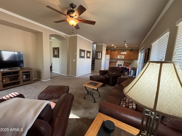 living room with ceiling fan, light colored carpet, and crown molding