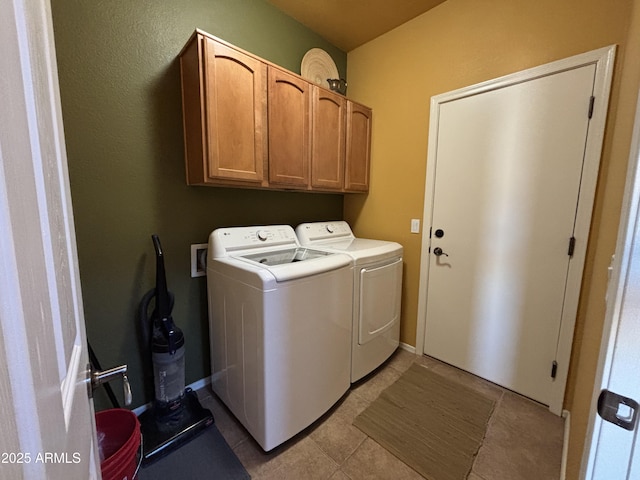 clothes washing area with cabinets, light tile patterned floors, and independent washer and dryer