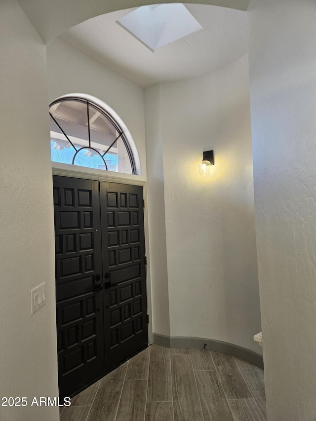 foyer entrance featuring a skylight