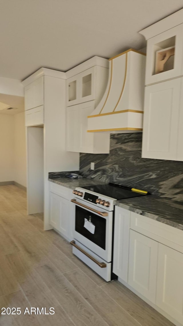 kitchen with white cabinetry, white range with electric cooktop, and custom range hood